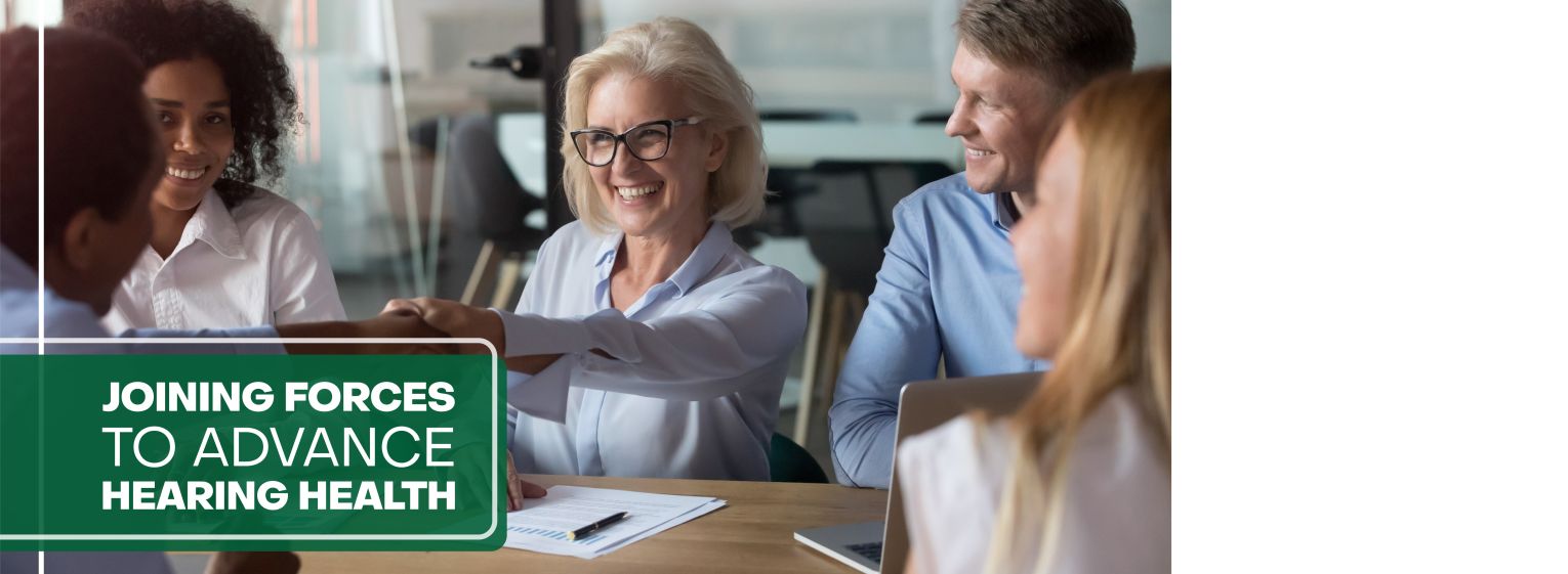 Woman and man smiling and shaking hands in office